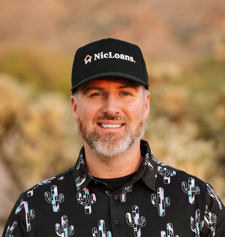 Nic Feinstein outside in the Arizona desert, wearing a NicLoans cap